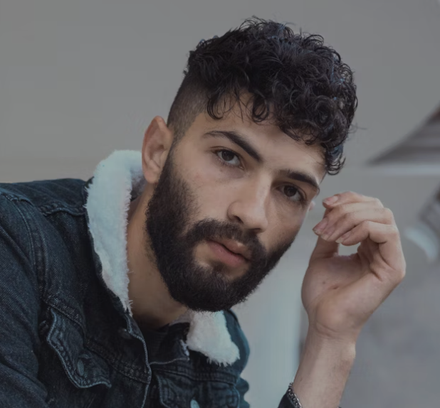 Bearded man touching groomed face